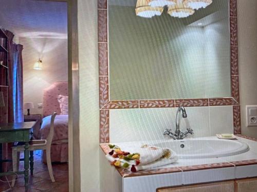 une salle de bain avec baignoire et une chambre avec un lit dans l'établissement La Combe de Lamaron, à Bollène