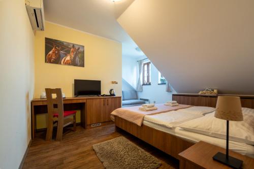1 dormitorio con 1 cama y escritorio con ordenador en Hospůdka na Haldě, en Boršice
