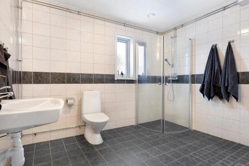 y baño con aseo, lavabo y ducha. en Guestly Homes - Homely 2BR Apartment with 3 Beds en Boden