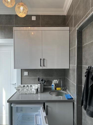 a kitchen with white cabinets and a sink at Imperial Suits in Istanbul