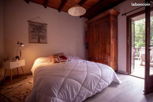 Un dormitorio con una gran cama blanca y una ventana en LA BOULZANE en Puilaurens