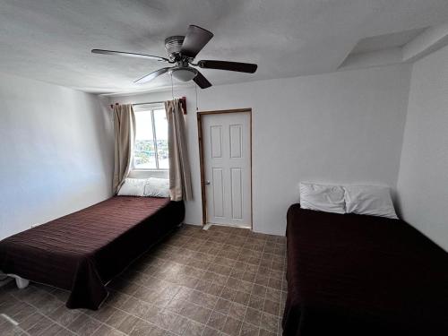 1 dormitorio con 2 camas y ventilador de techo en Whale Hill en Puerto Peñasco