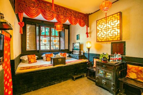 Pingyao Ji Family Courtyard Inn في بينغياو: غرفه فيها سرير وتلفزيون