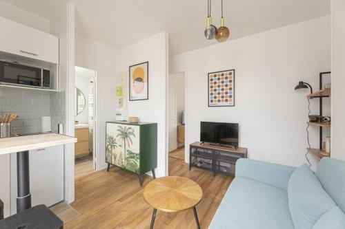 un salon avec un canapé bleu et une table dans l'établissement Apartment 1 Bedroom # Paris 14 # Alesia, à Paris