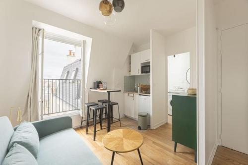 un salon avec un canapé et une table et une cuisine dans l'établissement Apartment 1 Bedroom # Paris 14 # Alesia, à Paris