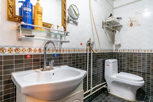 La salle de bains est pourvue d'un lavabo et de toilettes. dans l'établissement Pingyao Ji Family Courtyard Inn, à Pingyao