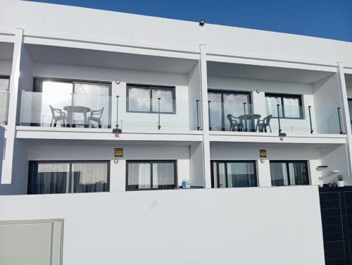 a white apartment building with two tables on the balcony at Vista Playa Blanca in Puerto del Rosario