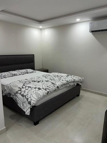 شقة في الرياض في حي قرطبة في الرياض: غرفة نوم بسرير في غرفة بيضاء