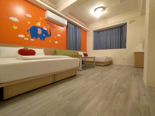 a bedroom with a bed and an orange wall at Penghu Le You You Homestay in Magong