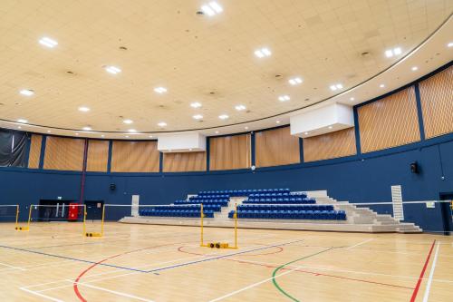 an empty gym with blue chairs and a basketball court at eStay Hotel in Dubai