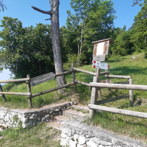a wooden fence with a sign next to a tree at Mansarda accogliente a Lusiana in Lusiana