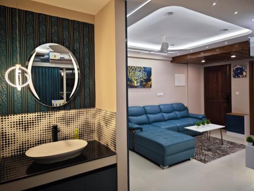 a living room with a blue couch and a mirror at Evara - Fully Air-Conditioned Luxury Apartment in Trivandrum