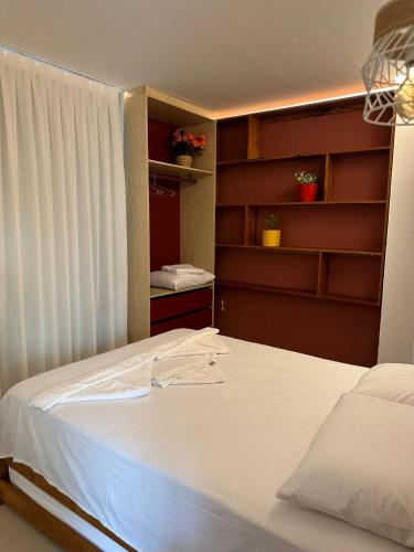 a bedroom with a bed and a closet with shelves at Apartamento Chique frente ao mar in Flecheiras