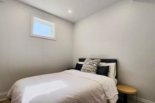a small bedroom with a bed and a small table at Serene High-celling Retreat in Oakville