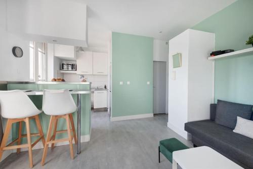 une cuisine et un salon avec un canapé et une table dans l'établissement Magnifique logement à 10 min du centre de Lyon, à Villeurbanne