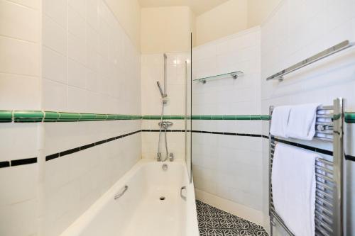 y baño con bañera y ducha. en The Cranley Gardens Escape - Spacious 2BDR Flat, en Palmers Green