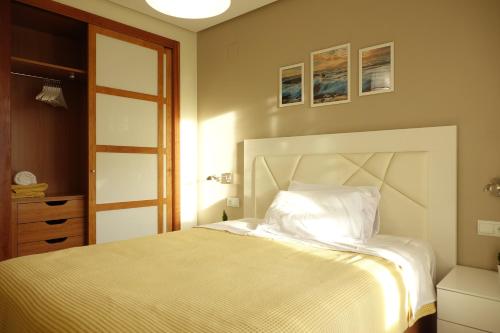 Palau de Congressos Great Stay Room في فالنسيا: غرفة نوم بسرير ولحاف ابيض