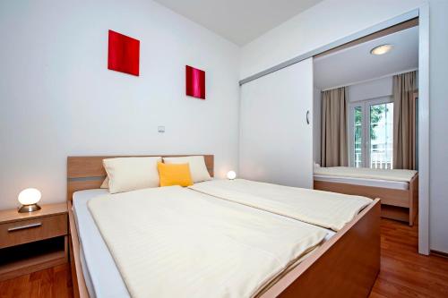una camera bianca con un grande letto e una finestra di Apartments and Room Marko a Rovigno (Rovinj)