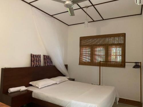 a bedroom with a bed and a window at Island Star POOL & SPA in Galle