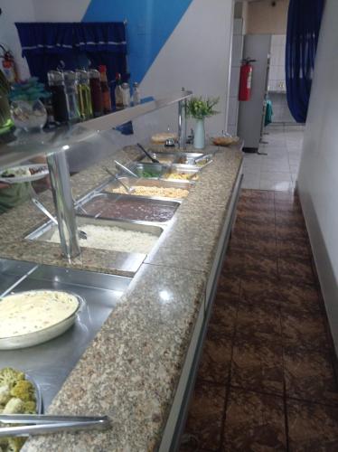 uma linha de buffet com muitos tipos diferentes de alimentos em BROKS Hotel e Restaurante em Fraiburgo