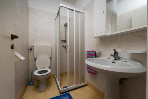 y baño con aseo, lavabo y ducha. en VILLAGGIO MICHELANGELO, en Bibione