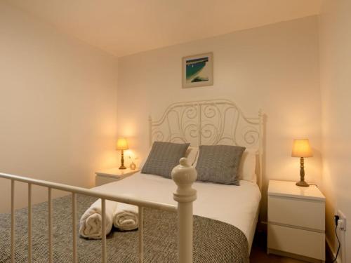 a bedroom with a white bed and two lamps at Chalet Bushwood Lodge by Interhome in Helston
