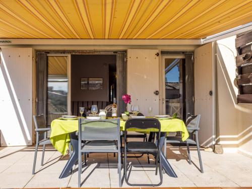 une table et des chaises sur une terrasse dotée d'un plafond jaune dans l'établissement Apartment Port La Roquille-2 by Interhome, au Cap d'Agde