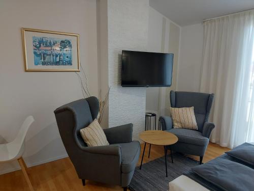 sala de estar con 2 sillas y TV de pantalla plana en Apartments Fantasia, en Pula