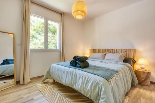 a bedroom with a large bed and a mirror at Résidence Escale Bleue in Andernos-les-Bains