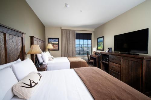 a hotel room with two beds and a flat screen tv at Bass Pro Shops Angler's Lodge in Hollister