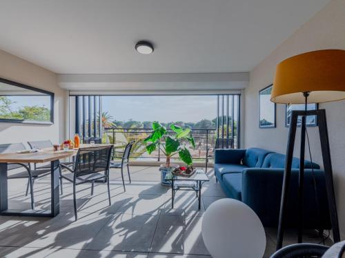 un salon avec un canapé bleu et une table dans l'établissement Apartment Horizon Golf by Interhome, à Saint-Cyprien