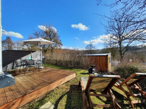 a wooden deck with a table and an umbrella at Holiday Home Birgit by Interhome in Wemding