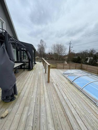 a wooden deck with a swimming pool on a house at The Cheerful Villa In Perstorp in Perstorp