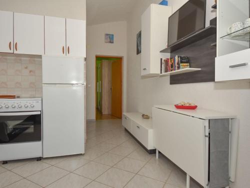 eine Küche mit weißen Schränken und einem weißen Kühlschrank in der Unterkunft Apartment Mia-3 by Interhome in Obrovac
