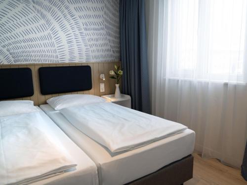 a bedroom with two white beds and a window at Apartment BEECH Resort Boltenhagen-2 by Interhome in Boltenhagen
