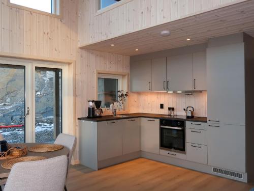 une cuisine avec des placards blancs et une table. dans l'établissement Holiday Home Hildebu - FJS156 by Interhome, à Sørbø