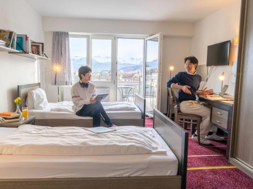 eine Gruppe von Personen, die in einem Hotelzimmer sitzen in der Unterkunft Apartment BHMS Lakeside Campus by Interhome in Luzern