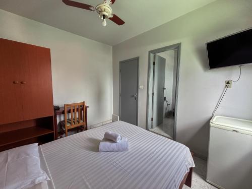 ein Schlafzimmer mit einem Bett und einem Handtuch darauf in der Unterkunft Carlton Express Imbiara in Araxá