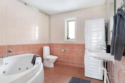 ein Badezimmer mit einer Badewanne, einem WC und einem Waschbecken in der Unterkunft Guestly Homes - 1BR Cozy Apartment in Boden