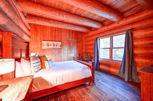 - une chambre avec un lit dans une cabane en rondins dans l'établissement Serenity Private Hot Tub - Sauna - Fiddler Lake, à Mille-Isles