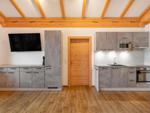 una cucina con elettrodomestici in acciaio inossidabile e una TV a schermo piatto di Apartment Hocheben by Interhome a Ramsau im Zillertal