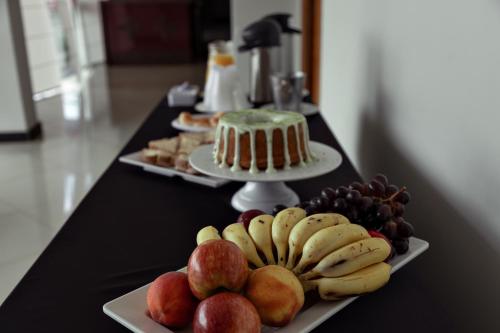 two plates of fruit on a table with a cake at Carlton Express Imbiara in Araxá