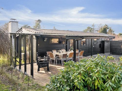 a wooden deck with a table and chairs at Holiday Home Arlina - 750m from the sea in Sealand by Interhome in Fårevejle