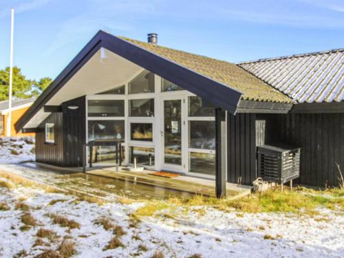 uma casa com grandes janelas e um telhado em Holiday Home Ubbe - 800m from the sea in Western Jutland by Interhome em Fanø