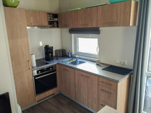 a small kitchen with wooden cabinets and a sink at Holiday Home Christian by Interhome in Wemding