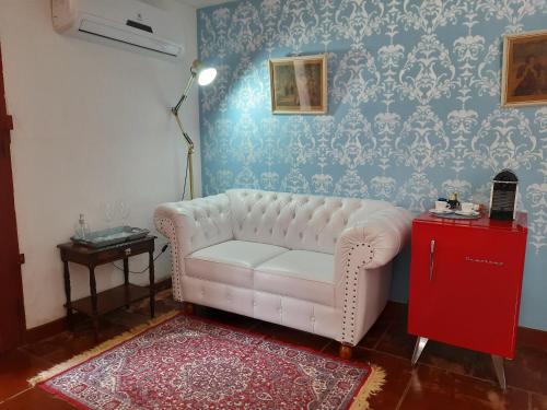 a living room with a white couch and a red cabinet at Agellum Bed & Breakfast in Domingos Martins