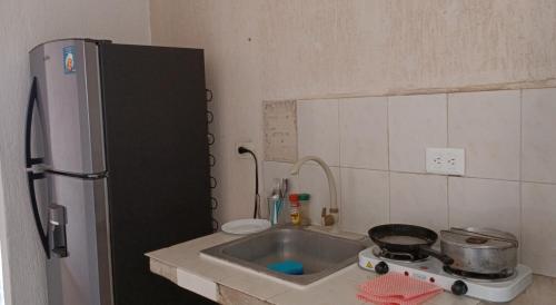 a small kitchen with a sink and a refrigerator at alojamiento económico in Mérida