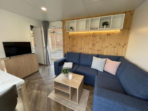 a living room with a blue couch and a tv at Holiday Home Tiny Haus Family-Home by Interhome in Riedenburg