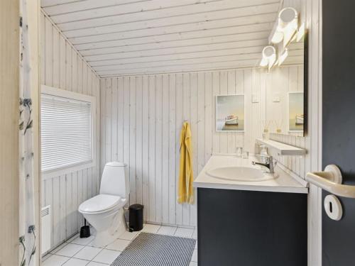 Baño blanco con lavabo y aseo en Holiday Home Ajvi - 900m from the sea in Sealand by Interhome, en Dronningmølle