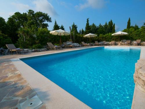 a swimming pool with chairs and umbrellas at Villa Mega by Interhome in Barban